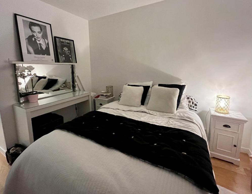 - une chambre avec un lit noir et blanc et une cheminée dans l'établissement Lovely flat near Paris, à Asnières-sur-Seine