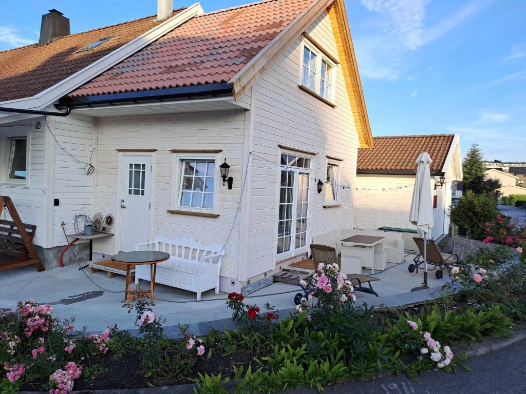 a small white house with a table and a patio at Apartment Tryms vei 20a - Elegant eget bygg in Kristiansand