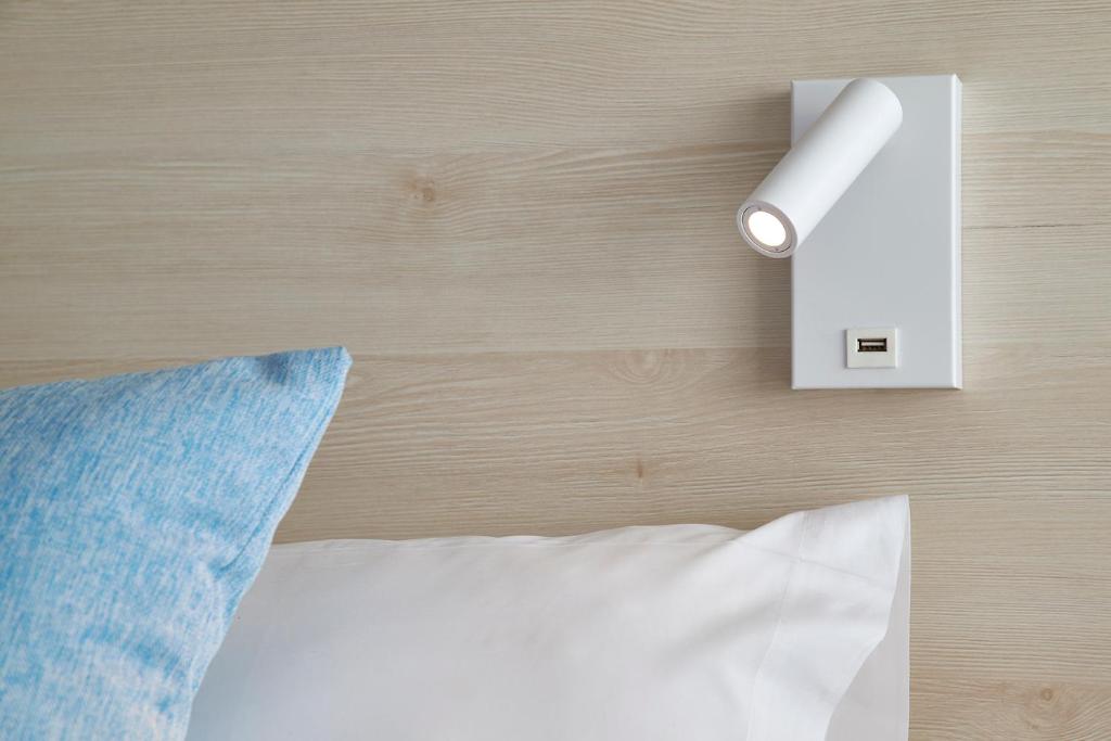 a light switch on a wall next to a bed at URH Excelsior in Lloret de Mar