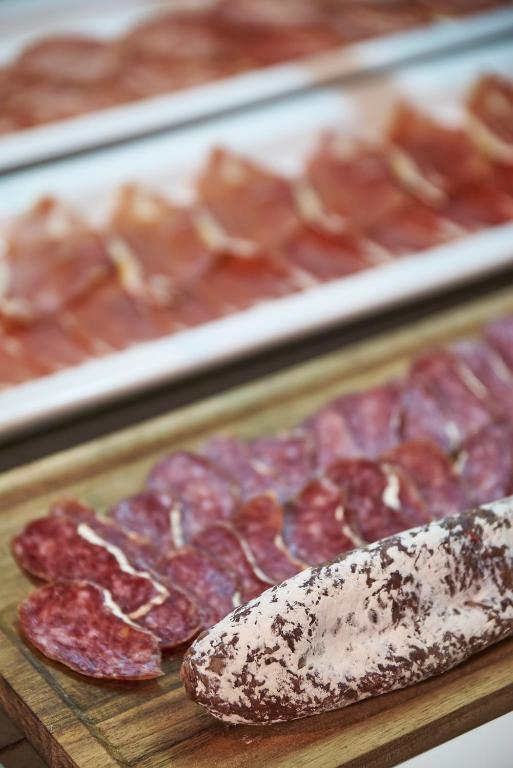 a bunch of different types of meat on a cutting board at URH Excelsior in Lloret de Mar
