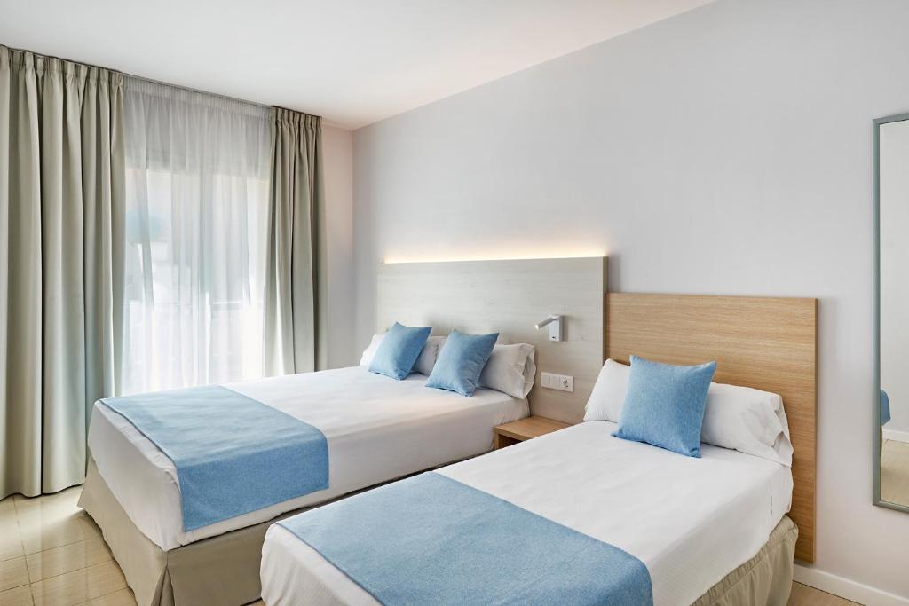 a hotel room with two beds and a window at URH Excelsior in Lloret de Mar