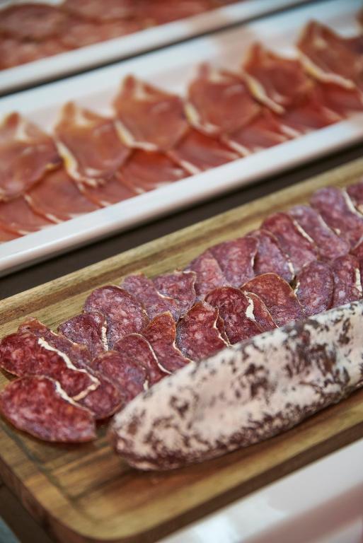 a bunch of different types of meat on a cutting board at URH Excelsior in Lloret de Mar