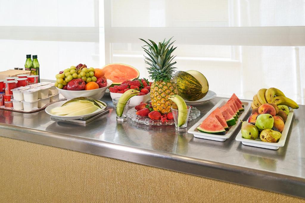 a bunch of fruit on a counter with bowls of fruit at URH Excelsior in Lloret de Mar