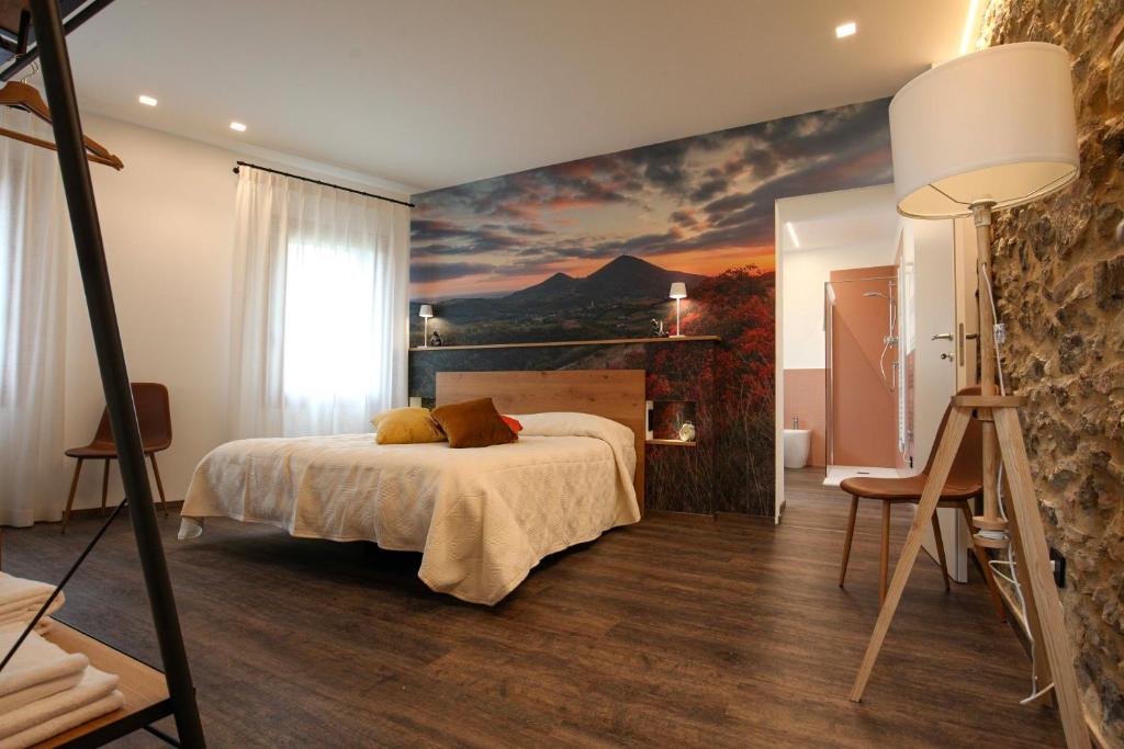 a bedroom with a bed with a painting on the wall at La Giuggiola in Arquà Petrarca