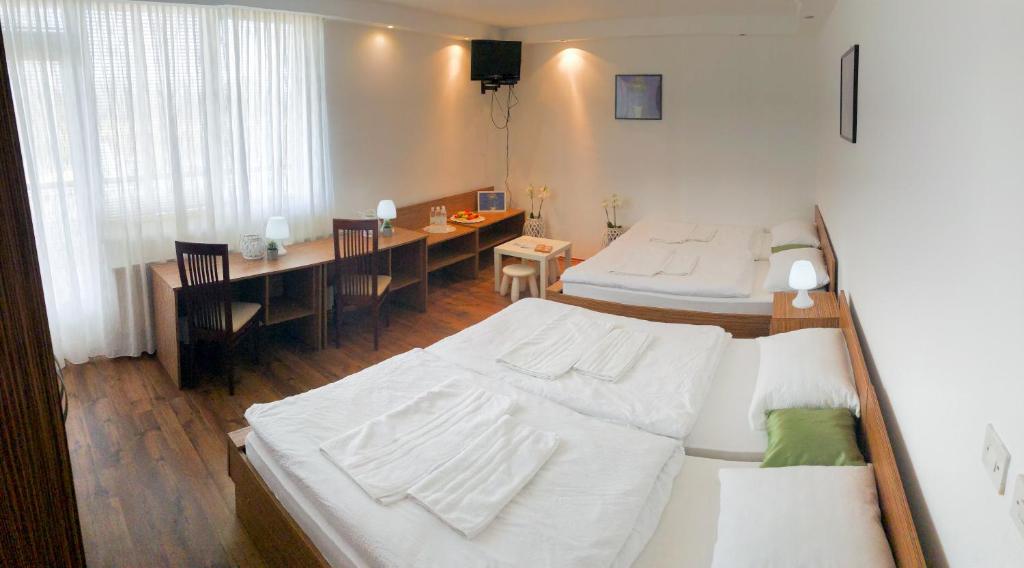 ein Schlafzimmer mit 2 Betten und ein Esszimmer mit einem Tisch in der Unterkunft Restavracija in prenočišča ČARDA in Martjanci