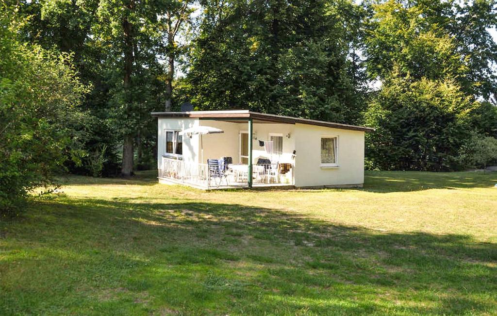 a small white shed in a field of grass at 2 Bedroom Cozy Home In Boitzenburger Land in Rosenow