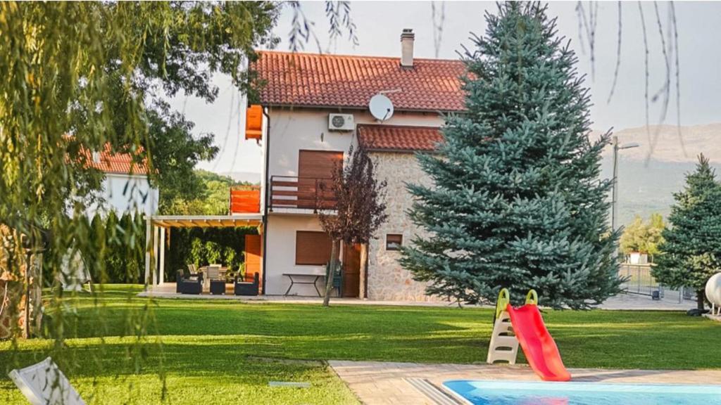 une maison avec un toit rouge et une aire de jeux dans l'établissement Villa Leko Dream House, à Cetina