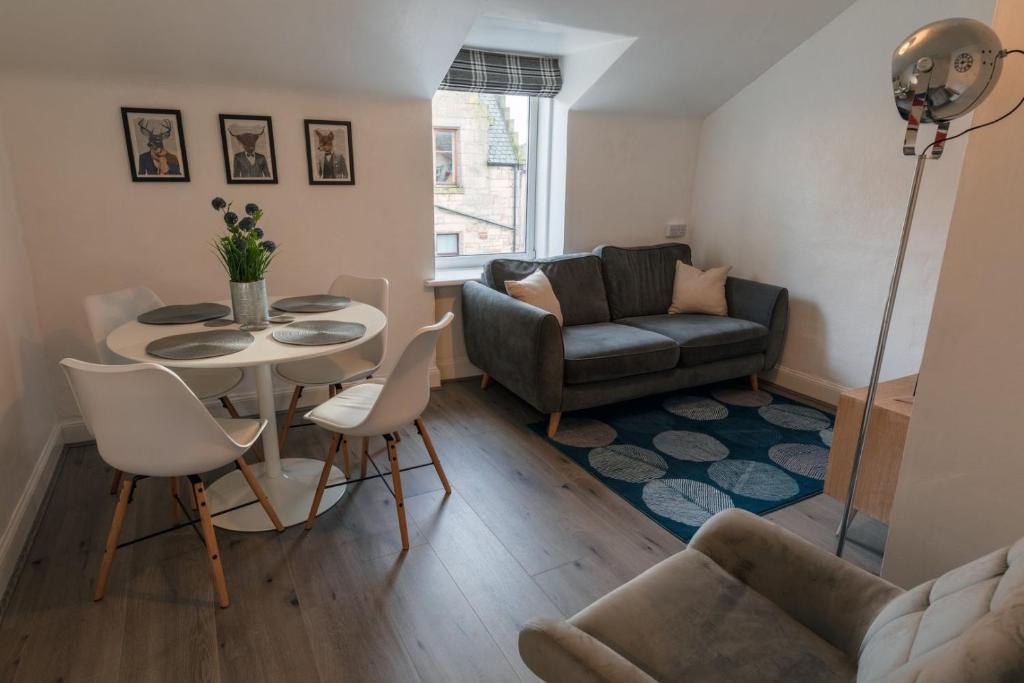 a living room with a table and a couch at Riverside Flat in Inverness