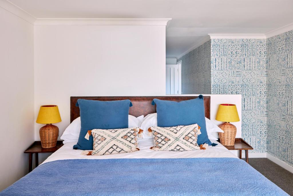 a bedroom with a blue and white bed with two lamps at No.26 By The Sea in Oban