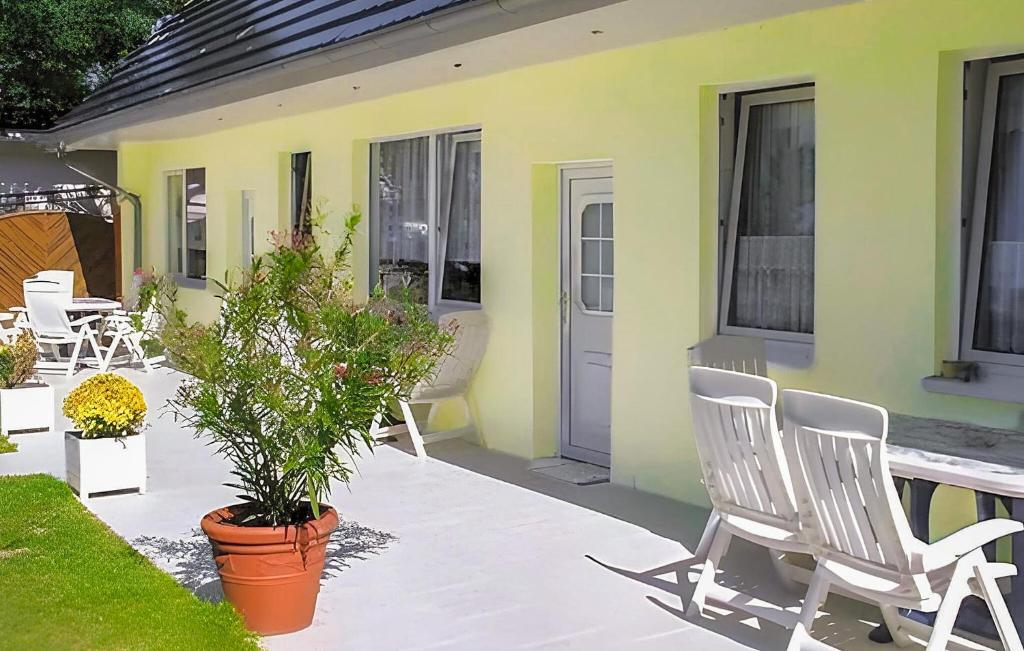 a patio with chairs and a table and a house at Cozy Apartment In Ostseebad Breege Ot Ju With Kitchen in Drewoldke