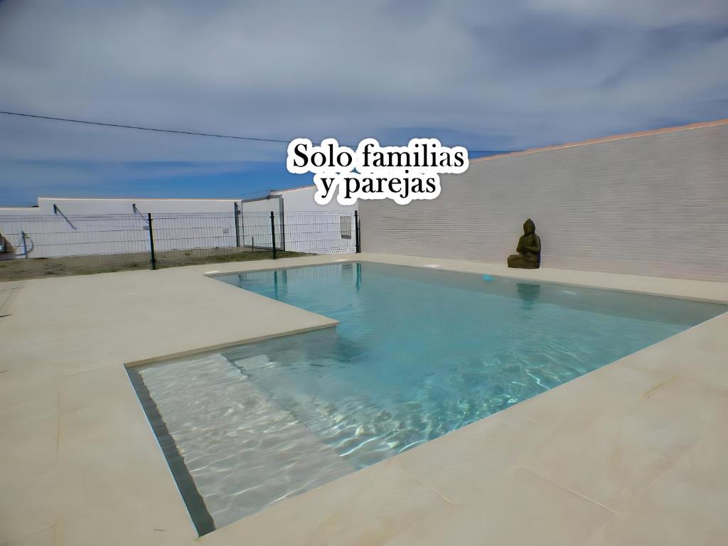 ein Pool mit einer Person neben einem Gebäude in der Unterkunft Casa rural Majadales piscina privada alta calidad in Conil de la Frontera