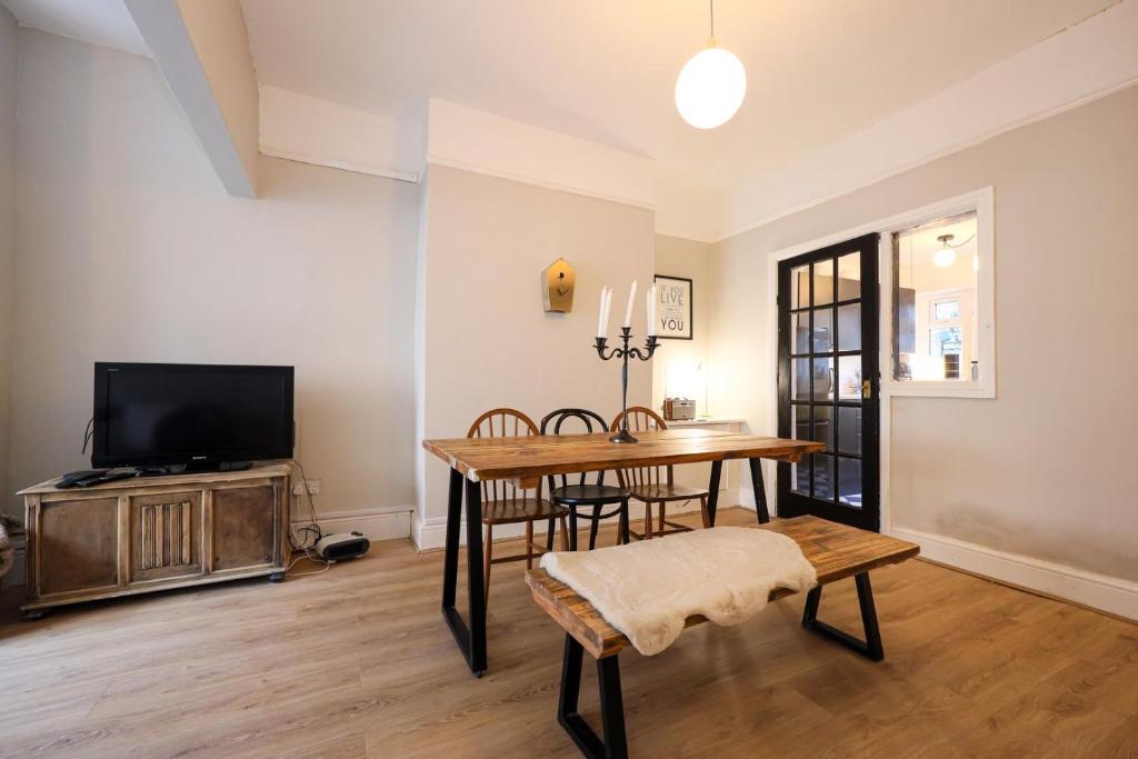 a living room with a table and a tv at GuestReady - Walton's Delight in Liverpool