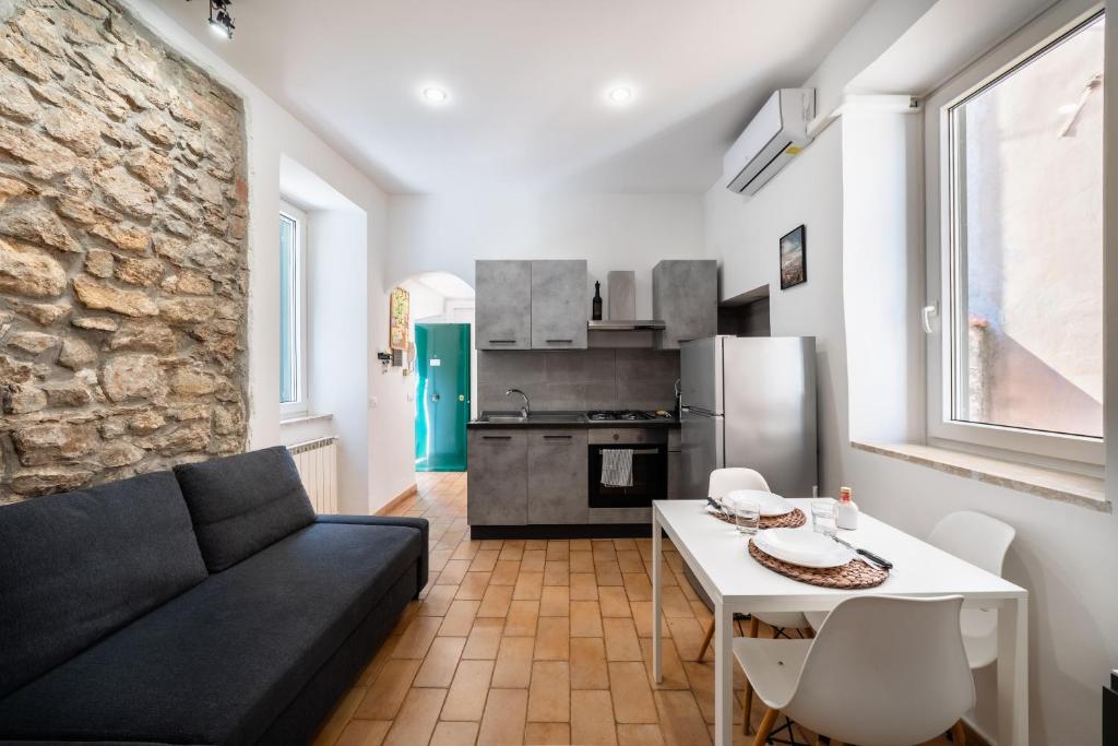 a living room with a couch and a table and a kitchen at Casa Gioia in Terracina