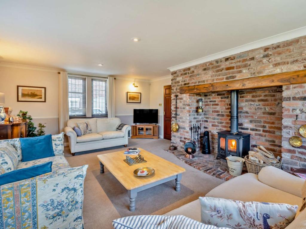 a living room with a fireplace and a brick wall at 4 Bed in Crosby-on-Eden 94398 in Crosby