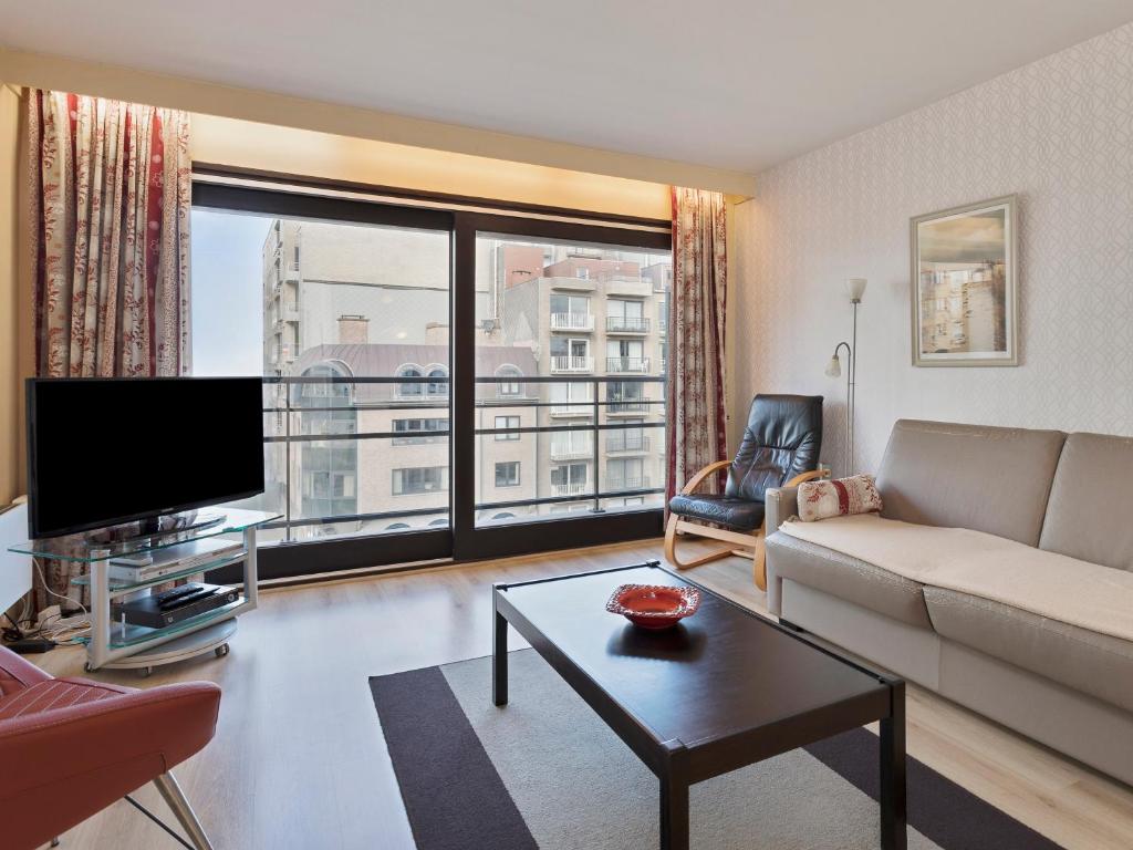 a living room with a couch and a large window at Wellington I C5 051 in Wenduine