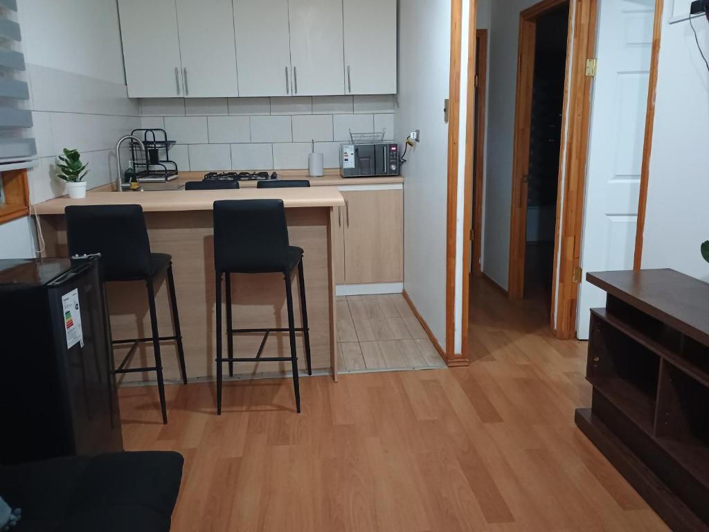 a kitchen with two bar stools and a counter top at CABAÑAS BRUJAS in Salamanca