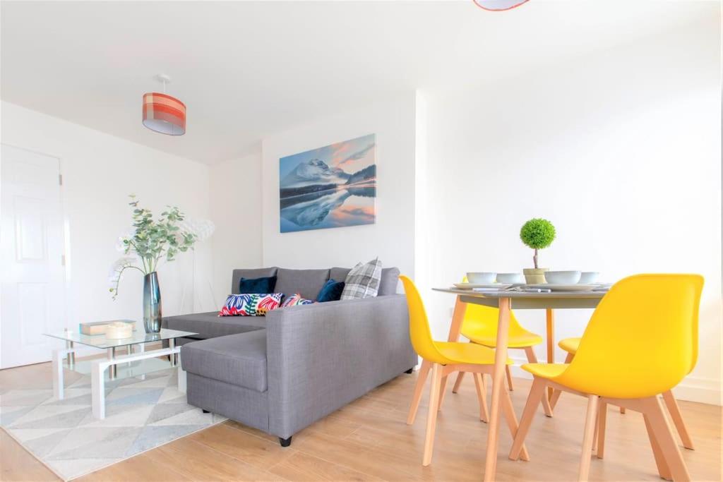 a living room with a table and yellow chairs at Riverside Rendezvous 1 bedroom Near Airport and City Centre SF in Liverpool