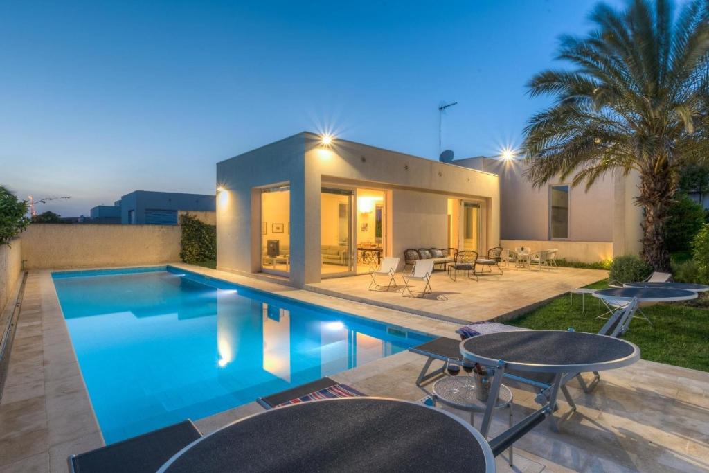 eine Villa mit einem Pool in der Nacht in der Unterkunft Ferienhaus in Ragusa mit Möblierter Terrasse in Marina di Ragusa