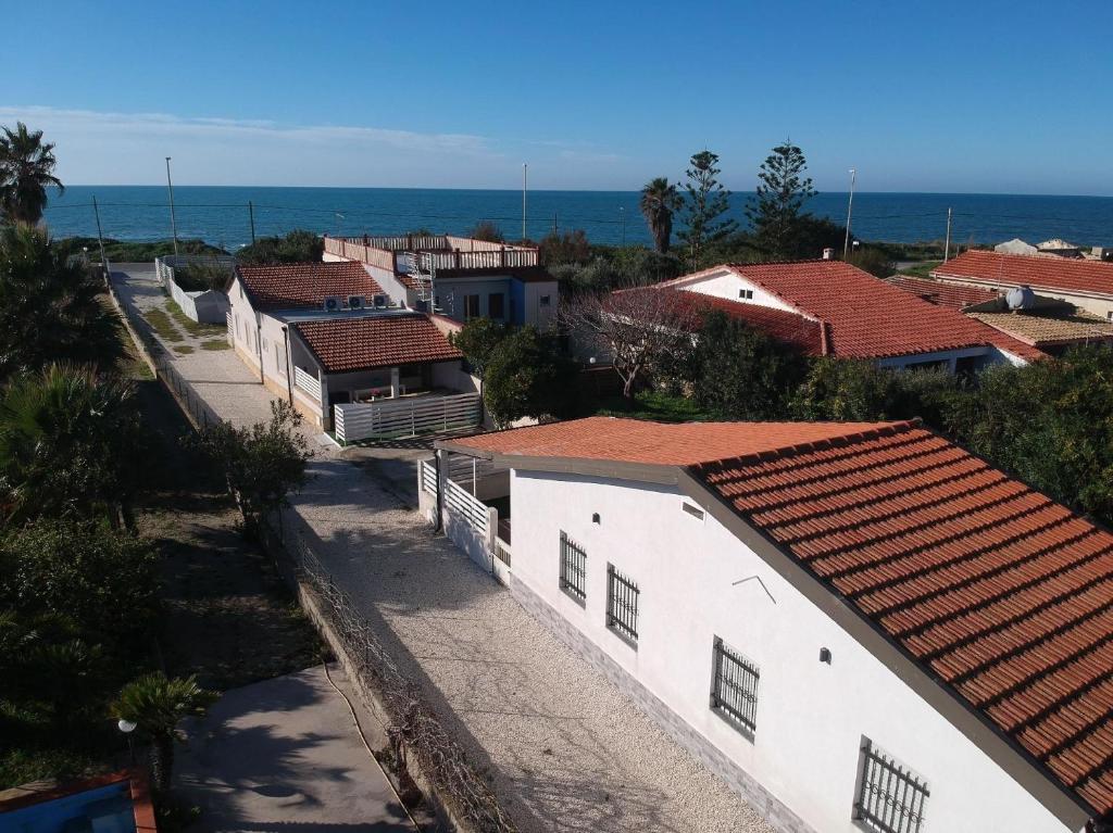 eine Stadt mit weißen Gebäuden und dem Meer in der Unterkunft Edoné, Wohnung mit Blick auf einen Sandstrand in Santa Maria Del Focallo