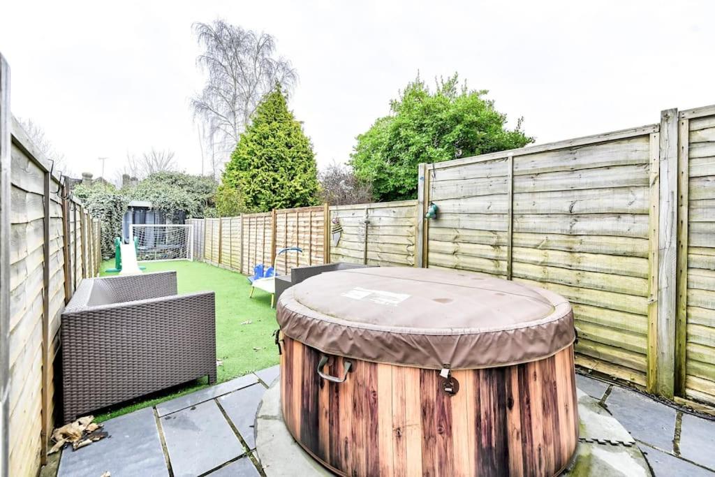 a large wooden barrel sitting in the middle of a yard at The Perfect Retreat-3 bedroom garden with Hot Tub in London