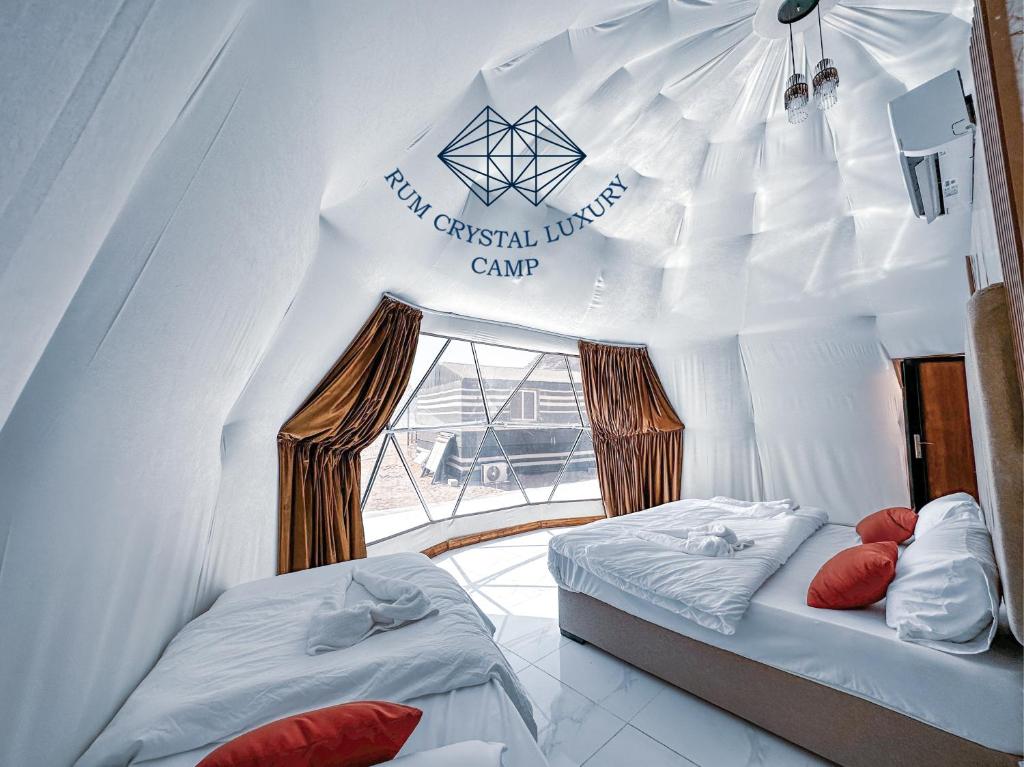 a room with two beds in a white tent at Rum Crystal Luxury Camp in Wadi Rum