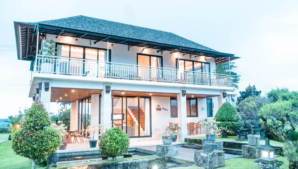 una casa con balcón en la parte superior en Dragonfly Cottage - 2Br Villa Jatiluwih, en Tabanan
