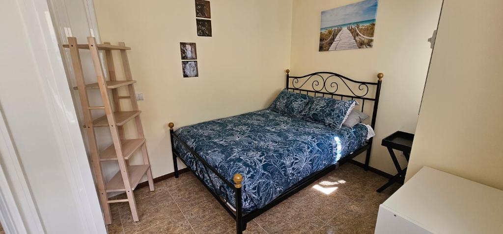 - une petite chambre avec un lit et une couette bleue dans l'établissement SUNAO, à Nazaré