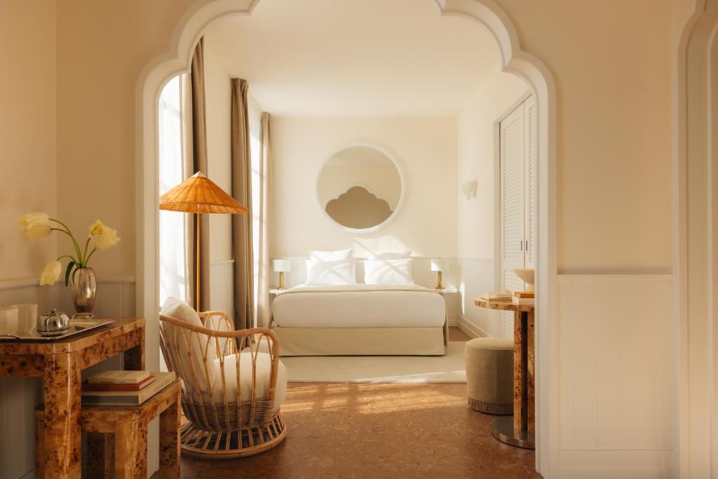 Un dormitorio con una cama y una mesa con una silla. en LILOU, en Hyères