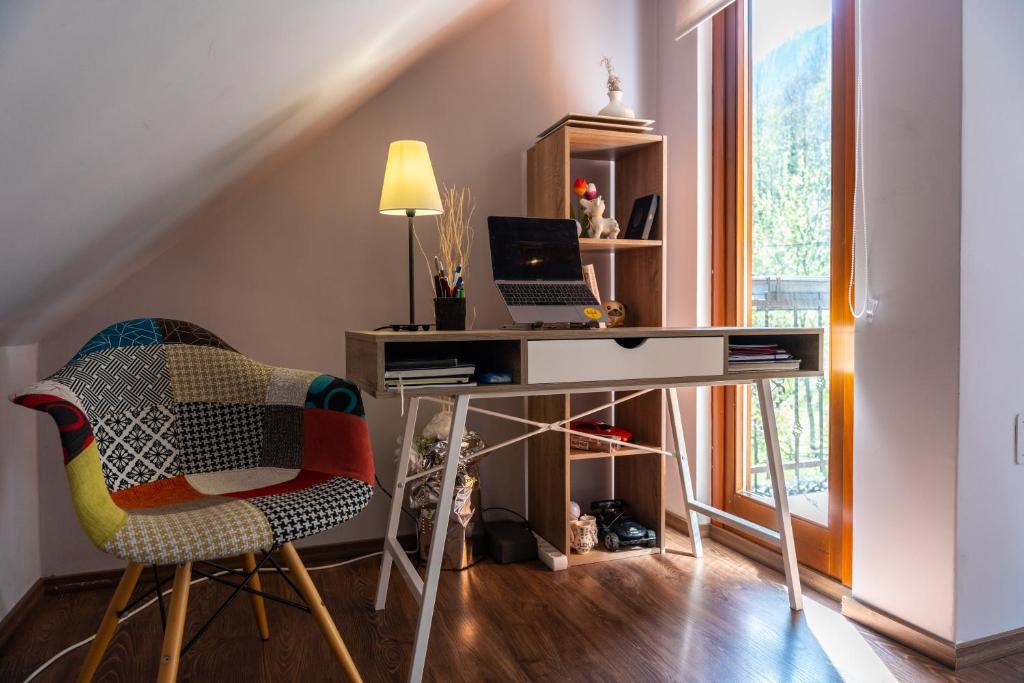 a desk with a laptop and a chair in a room at Holiday house Kajfes in Brod na Kupi