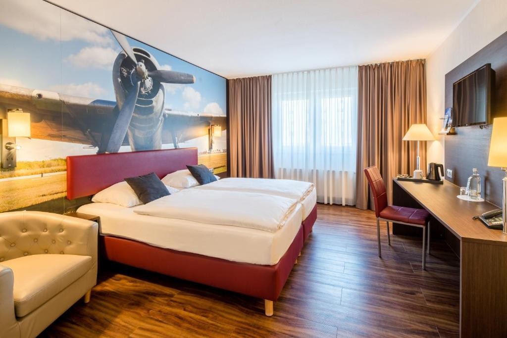 a hotel room with a bed and a desk at Airways Hotels Frankfurt Airport West in Raunheim