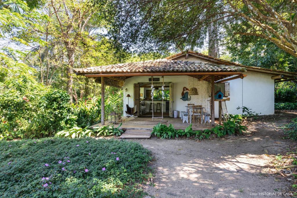 una pequeña casa blanca con un porche en el bosque en Casas da Lia, en Trancoso