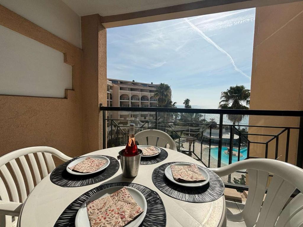 une table avec des assiettes de nourriture au sommet d'un balcon dans l'établissement Studio Cabine à Cannes la Bocca avec Piscines et Proche Plage - FR-1-609-33, à Cannes