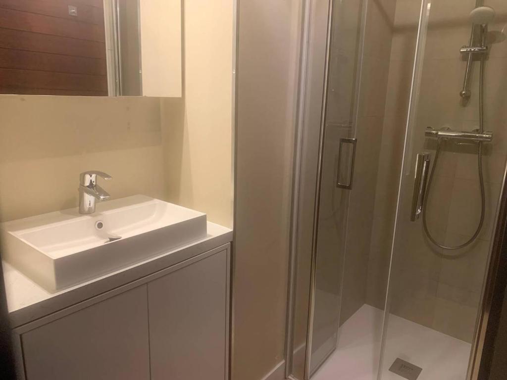 a white bathroom with a sink and a shower at Appartement Merville-Franceville-Plage, 3 pièces, 6 personnes - FR-1-465-87 in Merville-Franceville-Plage