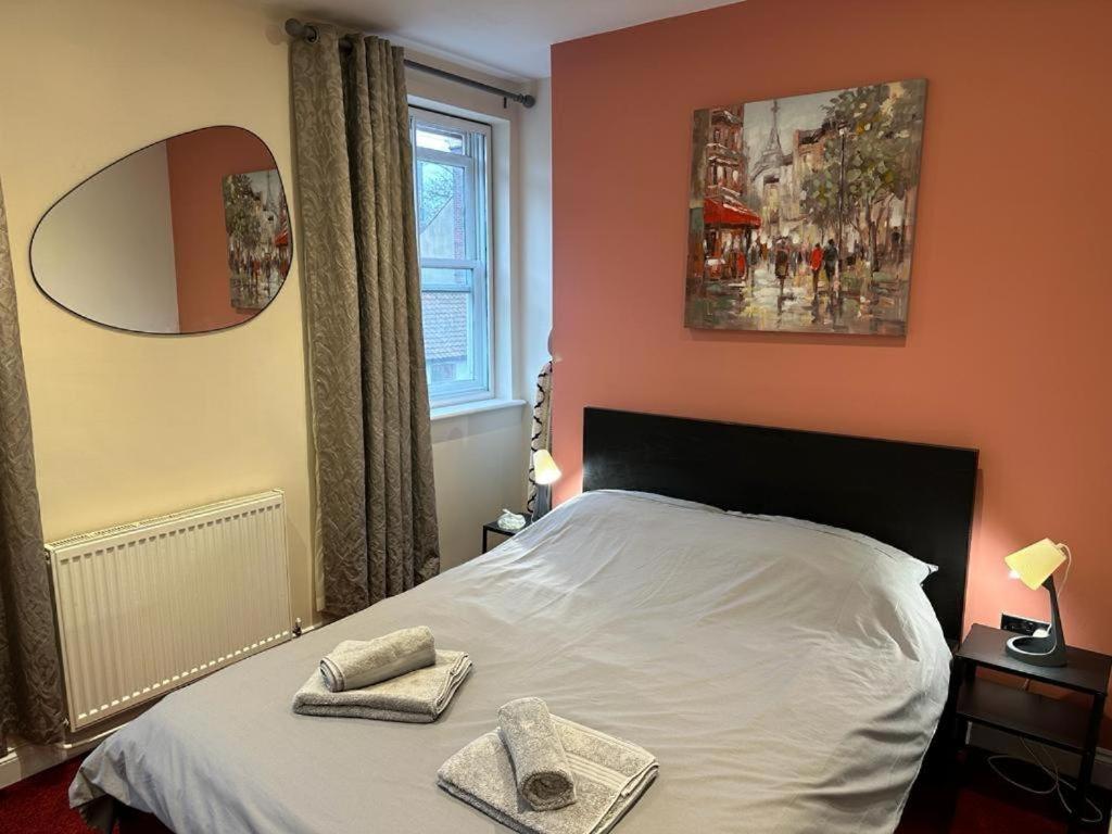 ein Schlafzimmer mit einem Bett mit zwei Handtüchern darauf in der Unterkunft Cosy and Comfy City Apartment in Norwich