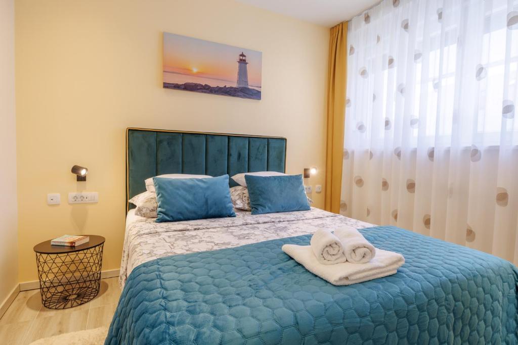 a bedroom with a bed with towels and a lighthouse at Perimar Luxury Apartments and Rooms Split Center in Split