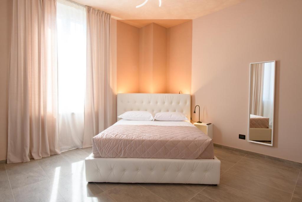 a white bed in a room with a large window at Room Don Alfonso Luxury in Parma