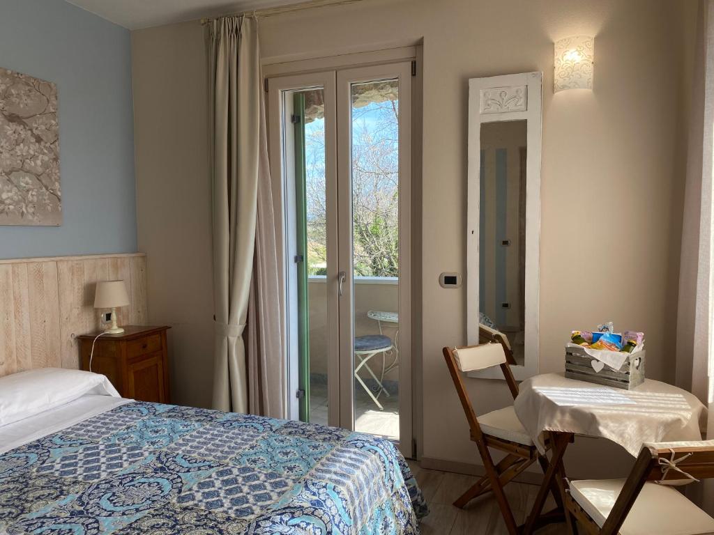 - une chambre avec un lit, une table et une chaise dans l'établissement Poggio Bardolino, à Bardolino