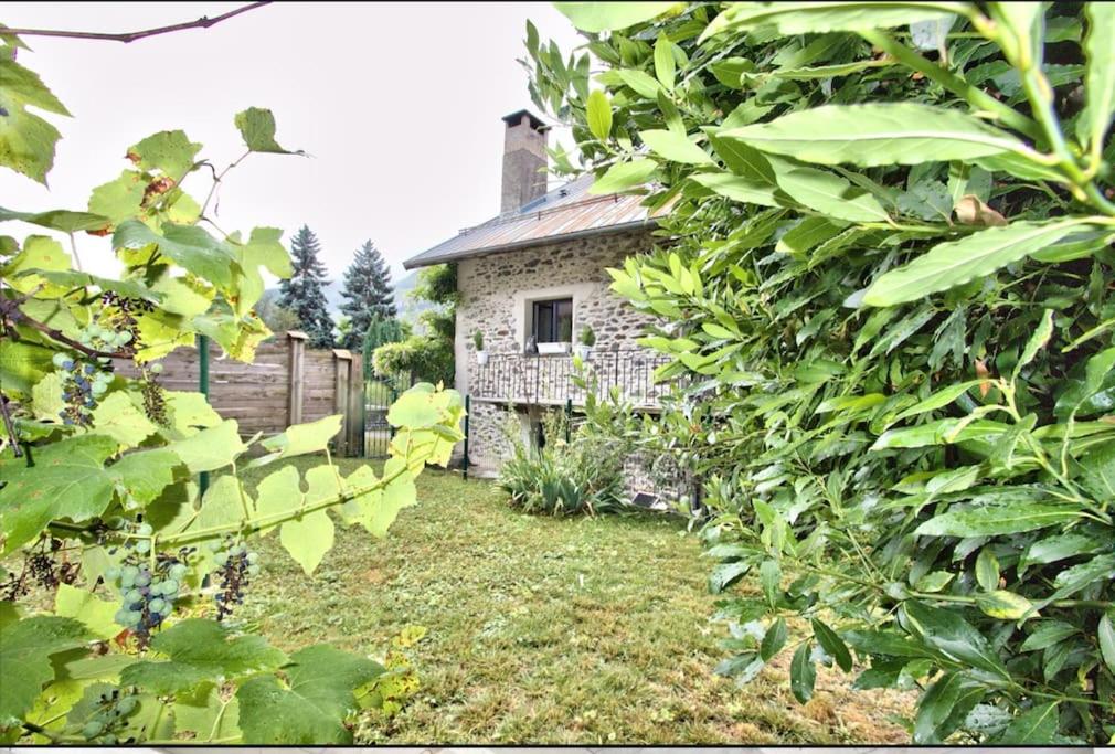 La Tour charmant studio très bien situé في Tours-en-Savoie: منزل حجري قديم في حديقة بها نباتات