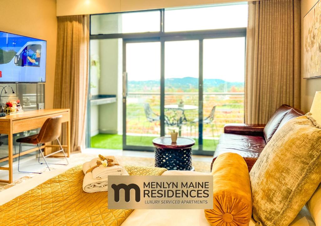 sala de estar con cama y ventana grande en Menlyn Maine Residences - Central Park with king sized bed en Pretoria