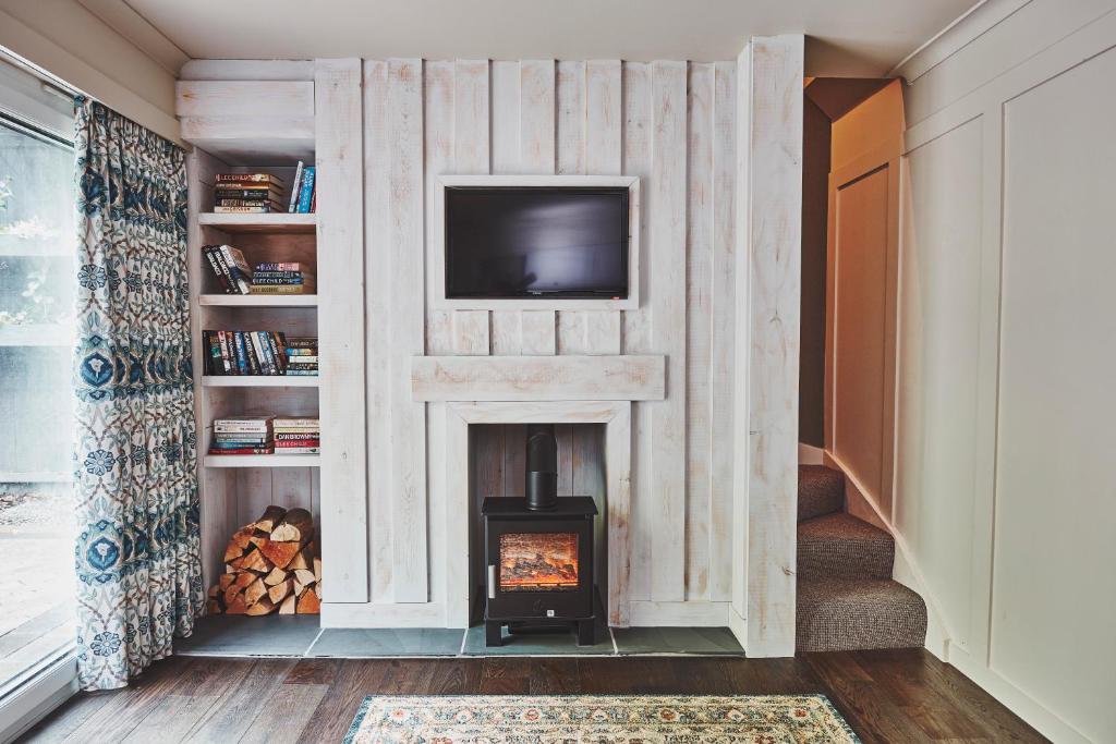 a living room with a fireplace with a tv above it at No.26 By The Sea in Oban