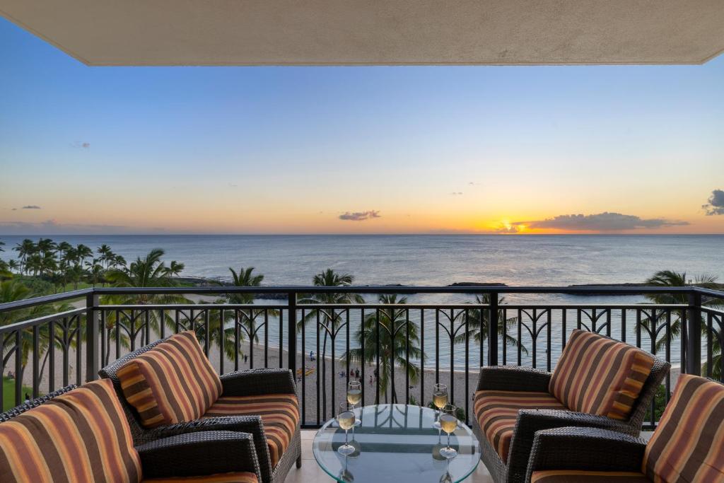 a balcony with two chairs and a table and the ocean at Ko Olina Beach Villas B610 in Kapolei