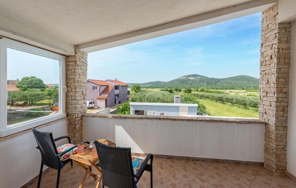 balkon ze stołem i krzesłami oraz dużym oknem w obiekcie Stunning Home In Gorica With Jacuzzi w mieście Gorica