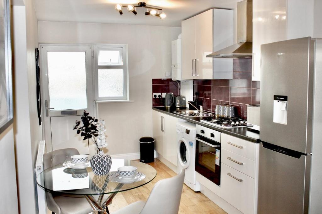 a kitchen with a glass table and a stainless steel refrigerator at Reading's Peaceful Gem in Reading