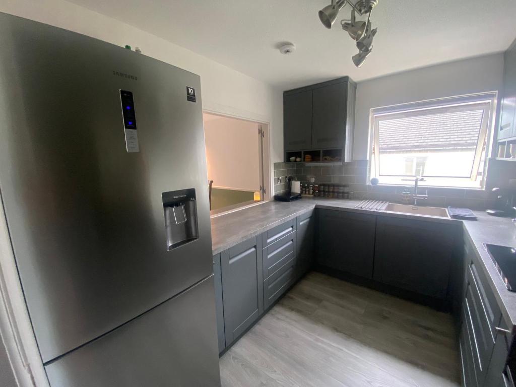 a kitchen with a stainless steel refrigerator and a sink at Modern Dublin Apartment in Dublin