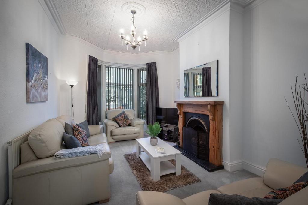 a living room with two couches and a fireplace at Delightful Family Home in Blackpool in Blackpool