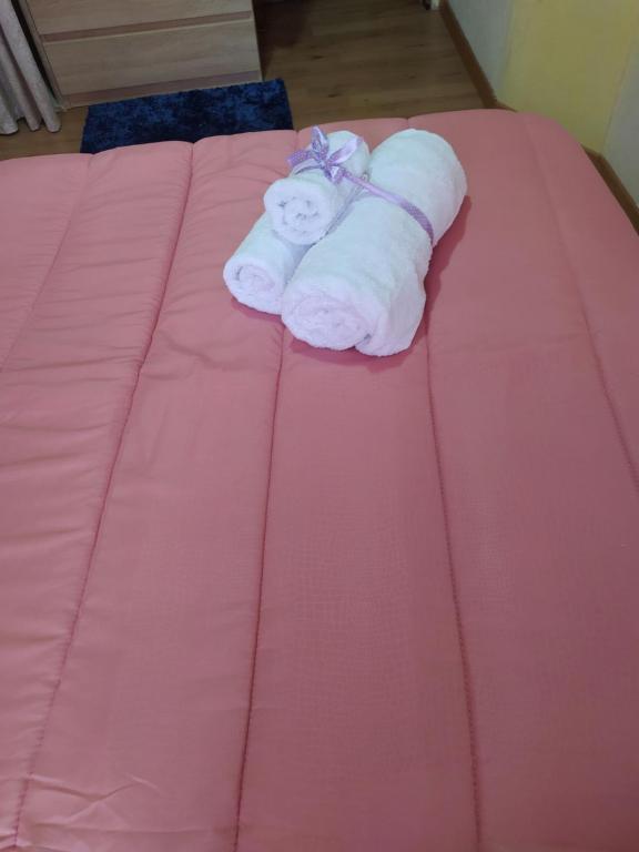 a pair of towels on a pink bed at Casa vacanza Su Niu in Iglesias