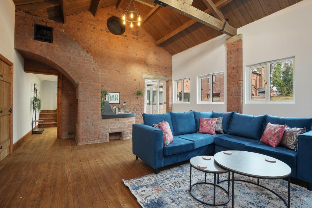 a living room with a blue couch and a table at Victorian Summer Retreat in Liverpool in Knowsley