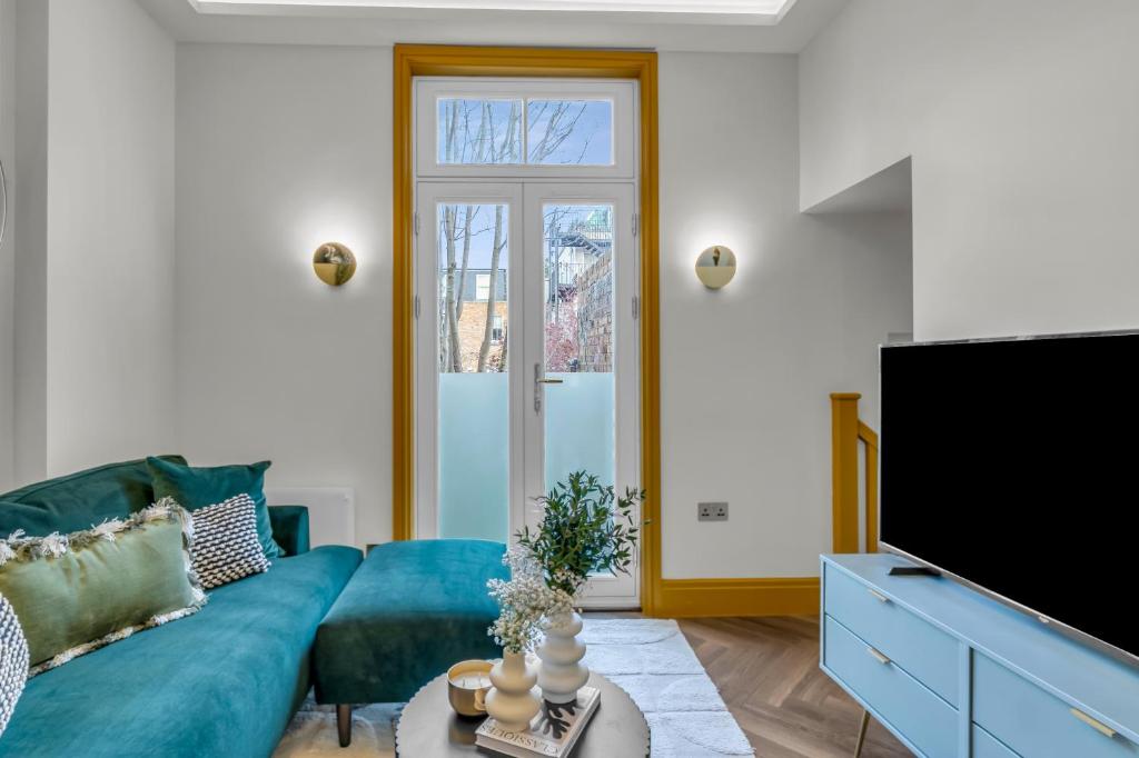 a living room with a blue couch and a tv at Hammersmith Residences by MySquare in London