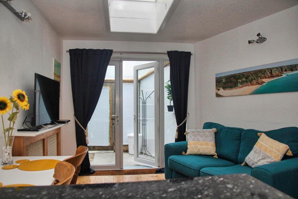 uma sala de estar com um sofá azul e uma mesa em Light and airy annexe with Parking em Bath