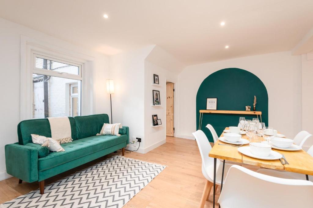 a living room with a green couch and a table at Seafront retreat in Margate in Kent